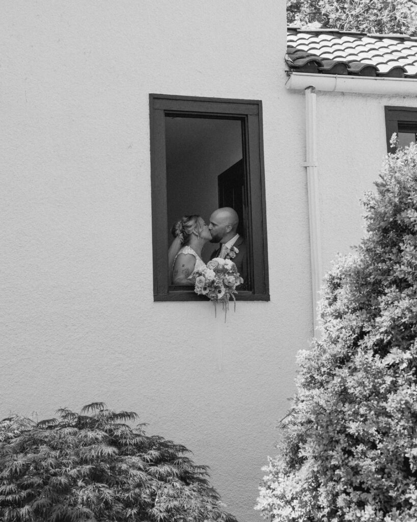 Bride and Groom embracing in a window at The Cottage at River Bend in Eagle, ID