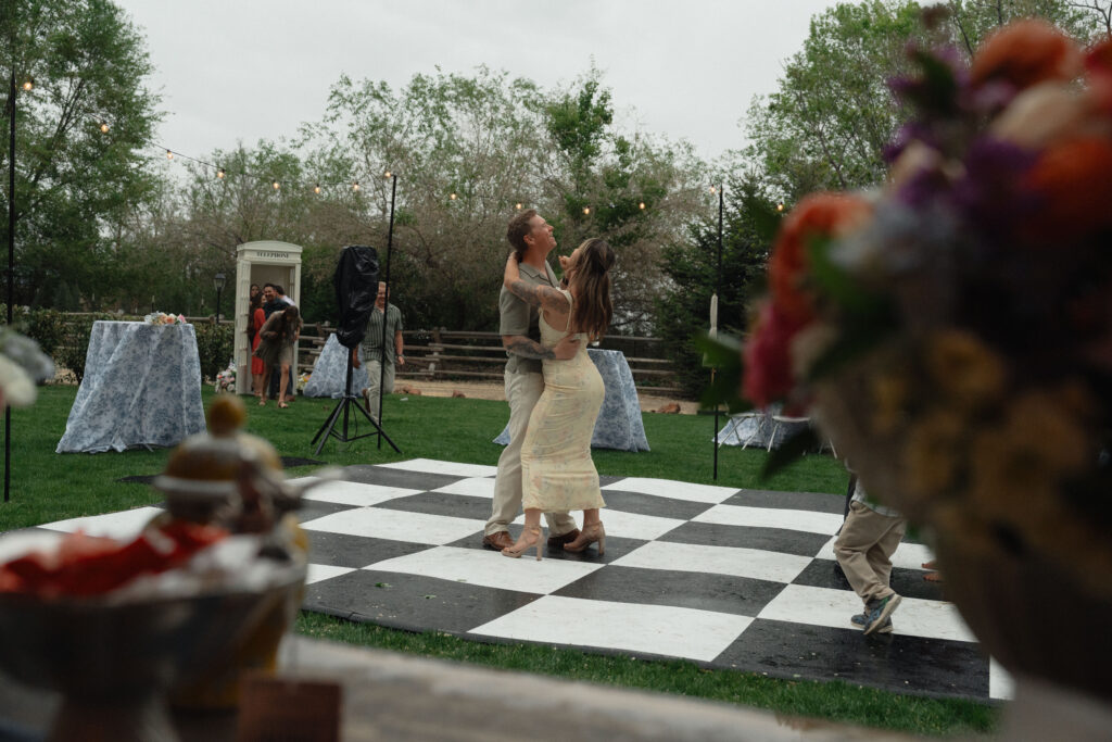 Couple dancing on outdoor checkered floor at The Cottage at River Bend in Eagle, Idaho.