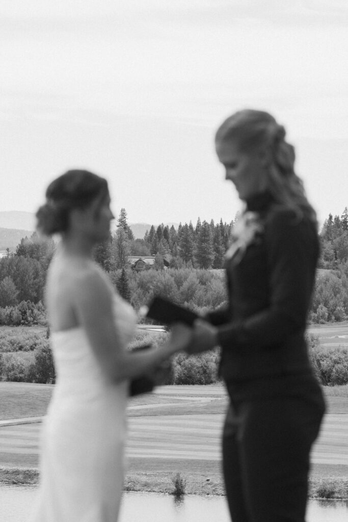 Bride and Bride reading their vows to each other in a private vow exchange at Tamarack Resort in Donnelly, ID
